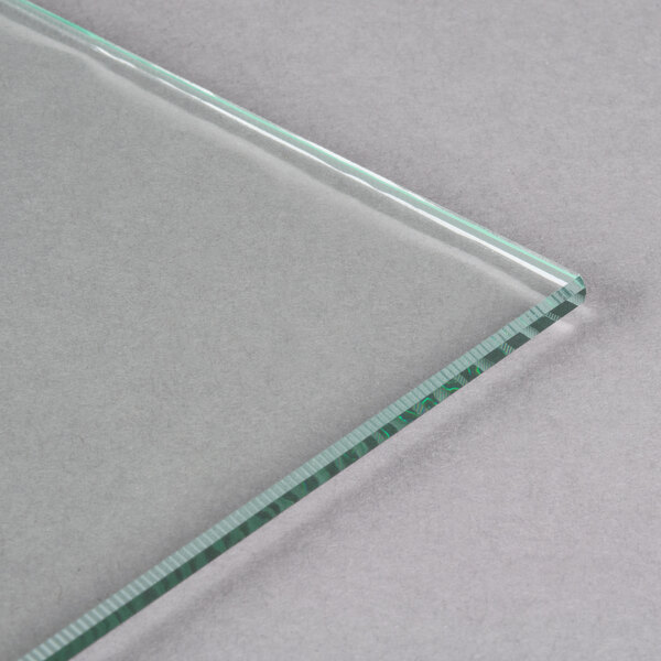 An Avantco glass panel with a green edge on a white surface.