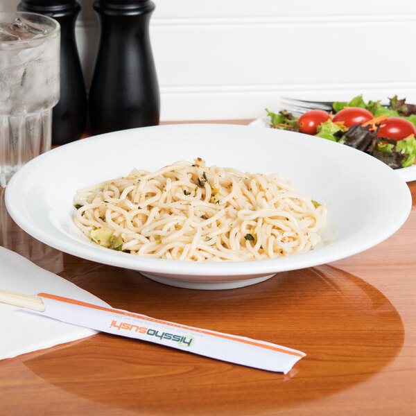 A CAC Super Bright White Coupe Porcelain bowl filled with noodles on a table.