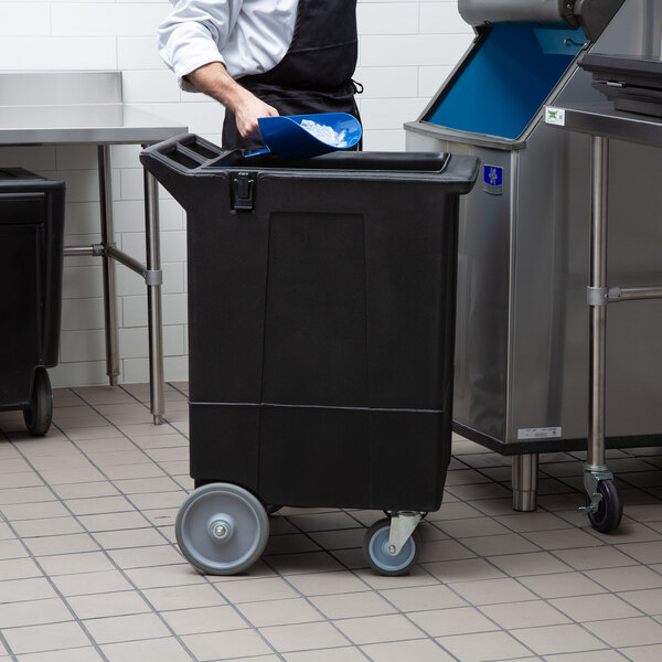 A man in a black plastic Carlisle mobile ice bin.