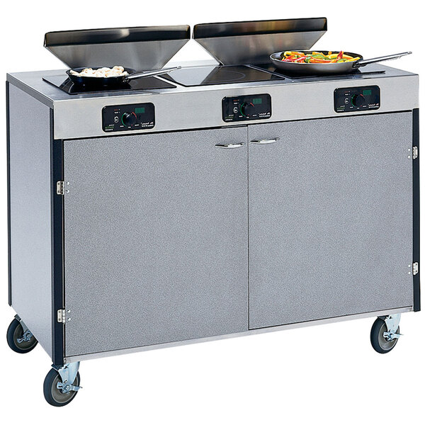 A Lakeside stainless steel cooking cart with induction burners and pans on it.