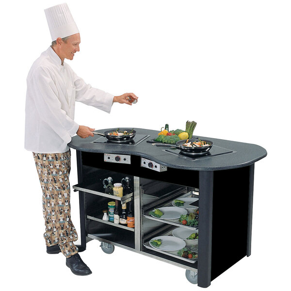 A chef using a Lakeside stainless steel cooking cart to cook in a professional kitchen.
