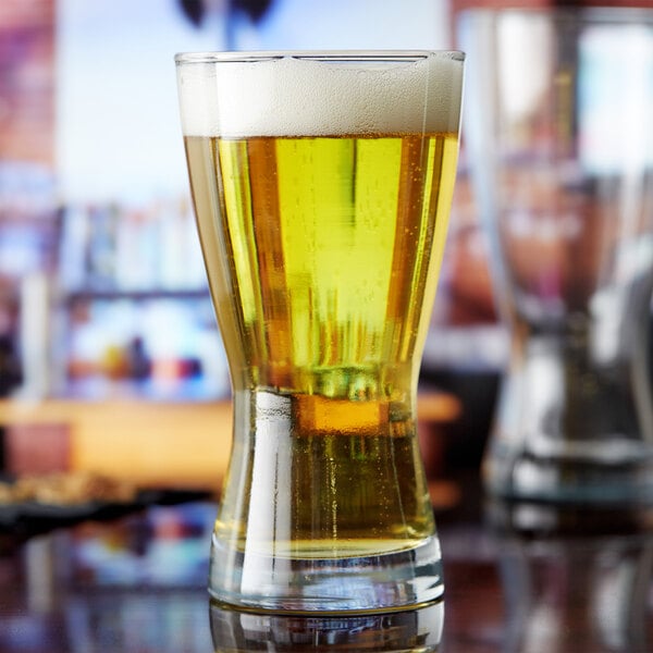 An Anchor Hocking Bavarian Pilsner glass full of beer on a counter.