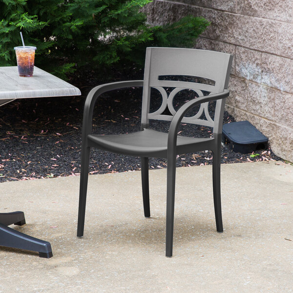 A Grosfillex Moon Titanium Gray outdoor chair on a patio.