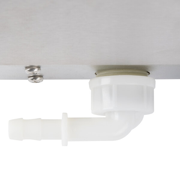 A close-up of a white plastic male fitting on a metal surface.