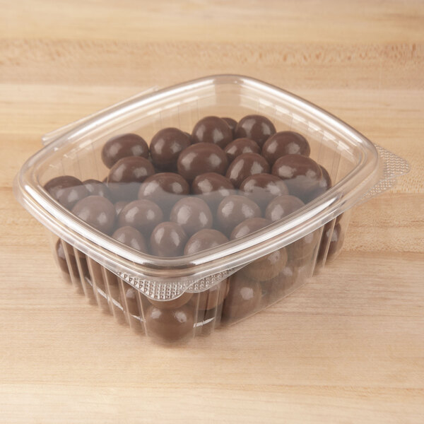 A Genpak clear plastic deli container filled with chocolate balls.