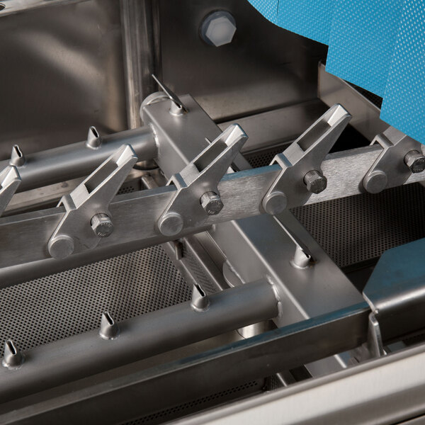 A close-up view of the internal stainless steel components of a commercial conveyor dishwasher.