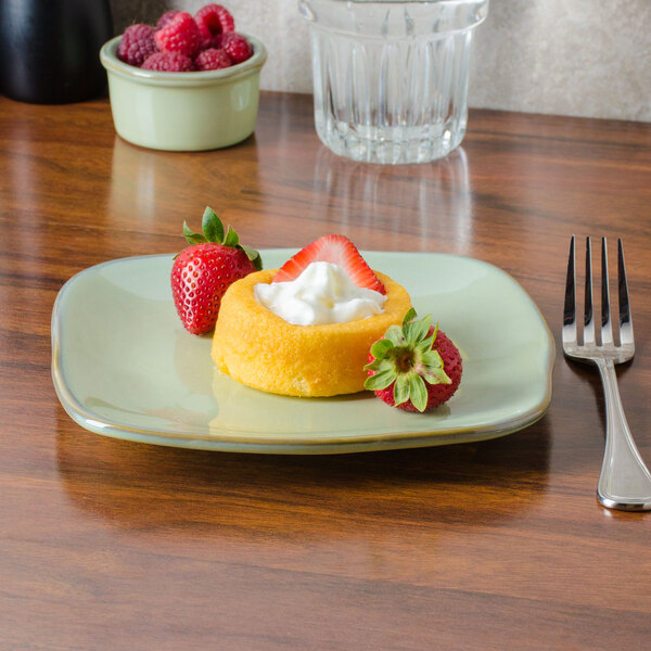 A Tuxton Artisan china plate with dessert including strawberries and whipped cream.