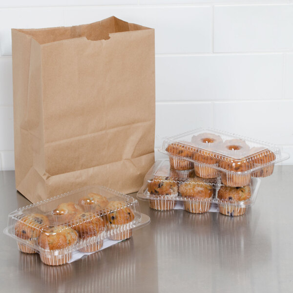 A group of muffins in plastic containers next to a Duro brown paper barrel sack.