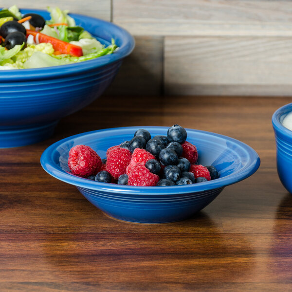 A Fiesta stacking china cereal bowl filled with blueberries and raspberries.