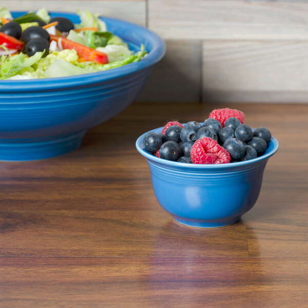 A bowl of salad with blueberries and raspberries.