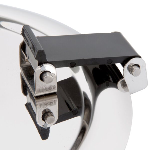 A close up of a metal lid with a black handle.