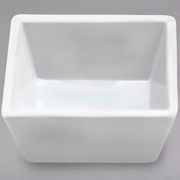 A white square Elite Global Solutions melamine sauce cup.