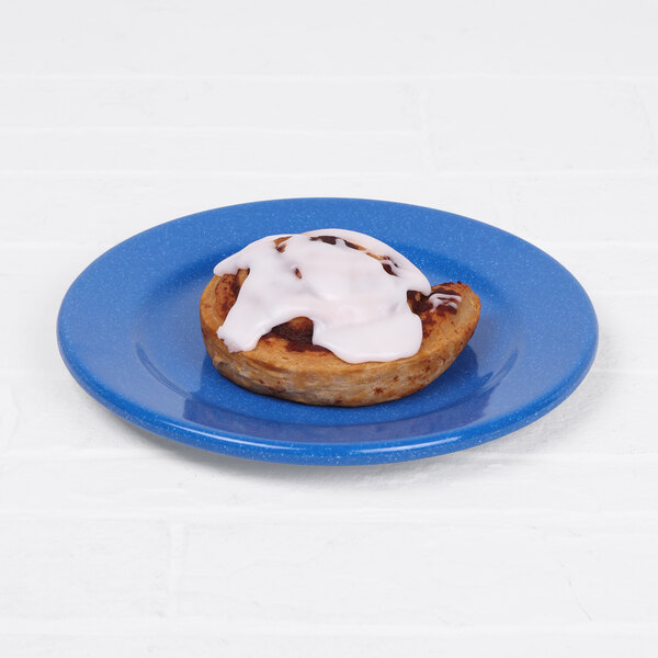 A cinnamon roll with white frosting on a blue Elite Global Solutions melamine plate.