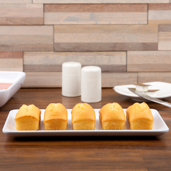A white rectangular GET Midtown melamine platter with food on a table.