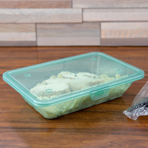 A jade GET Eco-Takeout container with food inside on a table.