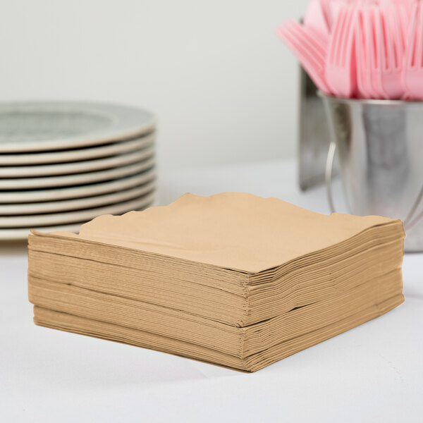 A stack of Creative Converting Glittering Gold paper napkins on a table.