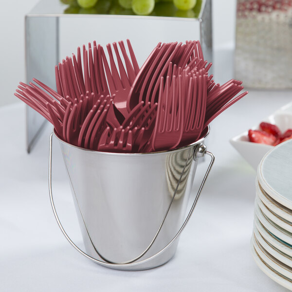A bucket of Creative Converting burgundy plastic forks.
