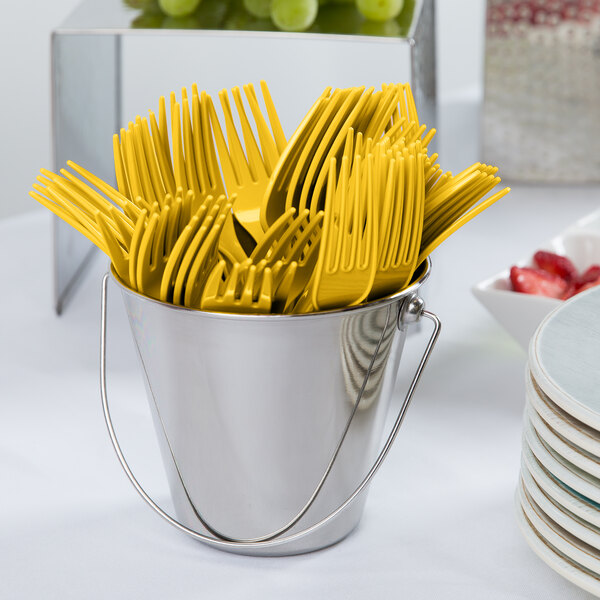 A bucket of yellow plastic forks.