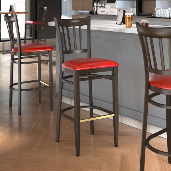 Lancaster Table & Seating Spartan Series Metal Slat Back Bar Stool with Dark Walnut Wood Grain Finish and Red Vinyl Seat - Assembled