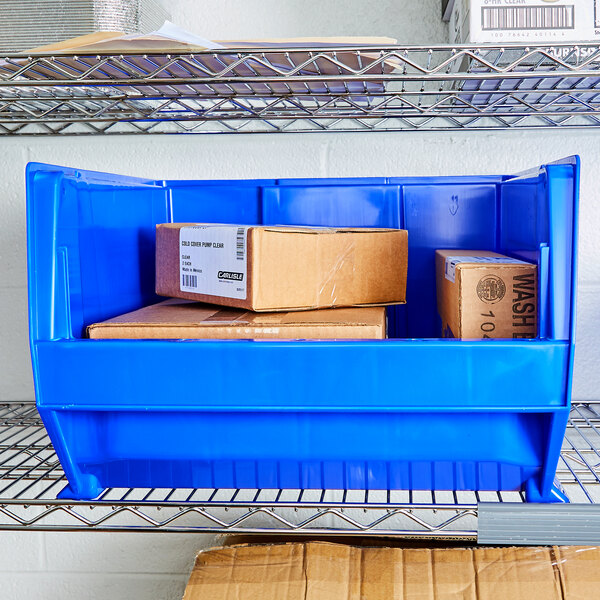 A blue plastic bin with brown boxes inside.