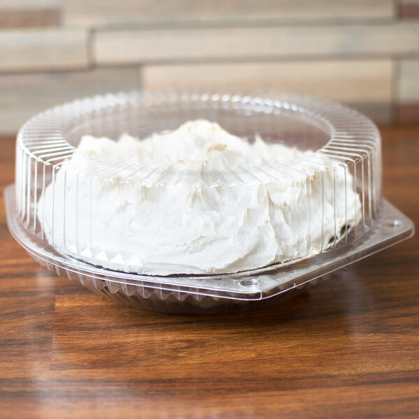 A cake in a Polar Pak clear plastic container with a white frosting.