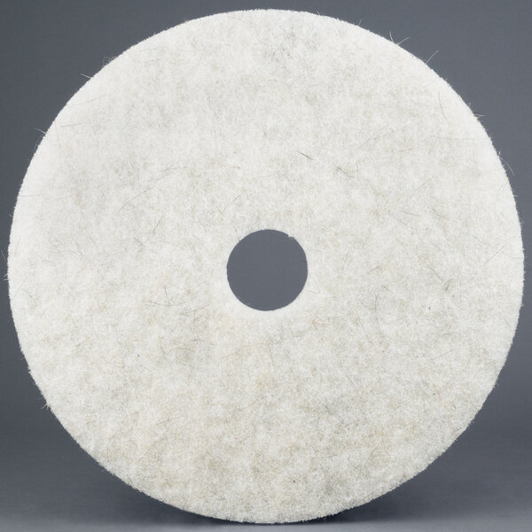 A white circular 3M Natural Blend burnishing floor pad with a hole in the middle.