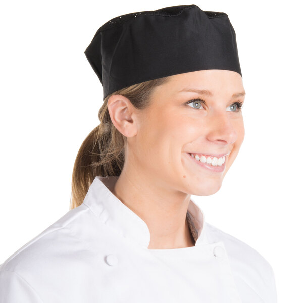 A woman wearing a black Chef Revival baker's skull cap with a mesh top.
