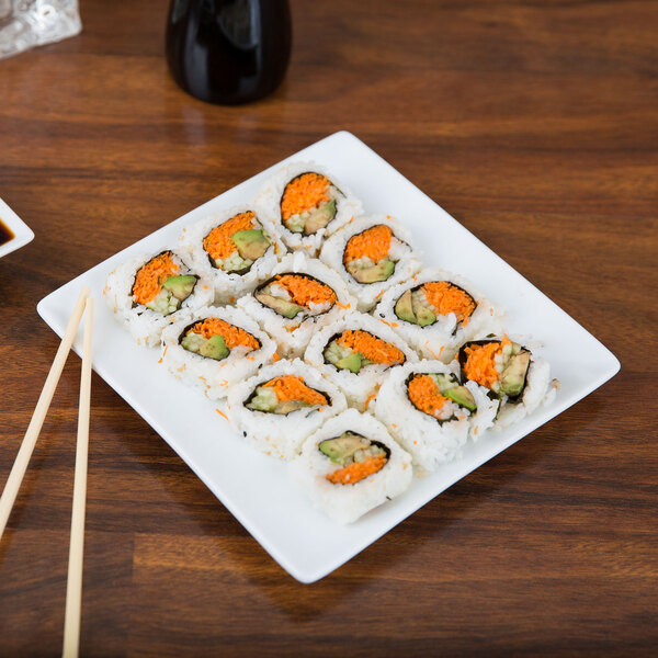 A Libbey Slate porcelain plate with sushi on a table.