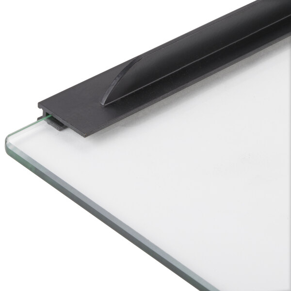 A close-up of a glass board with a black metal handle.