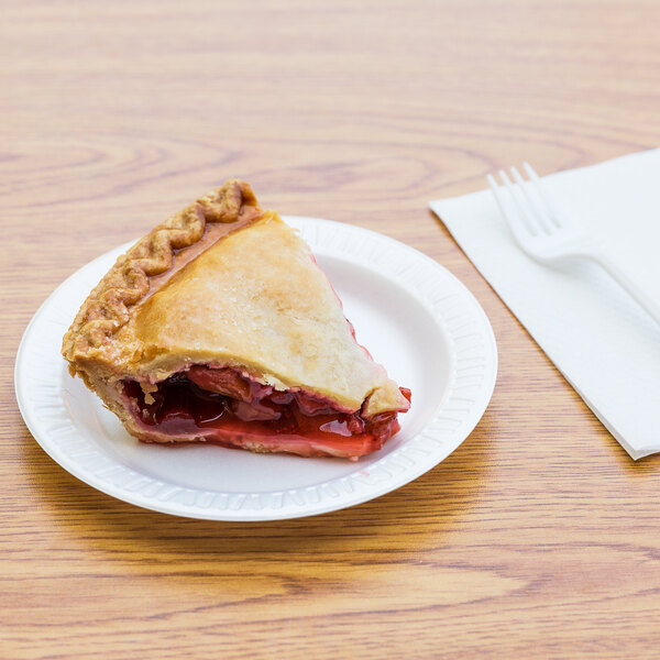 A slice of cherry pie on a Dart white foam plate next to a fork.