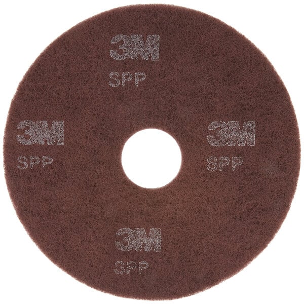A brown circular 3M Scotch-Brite surface preparation pad with white text.