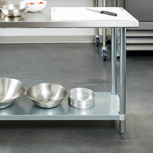 A Regency stainless steel work table with bowls on it.