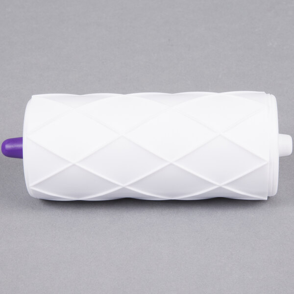 A white Wilton quilt pattern roller with a purple tip.