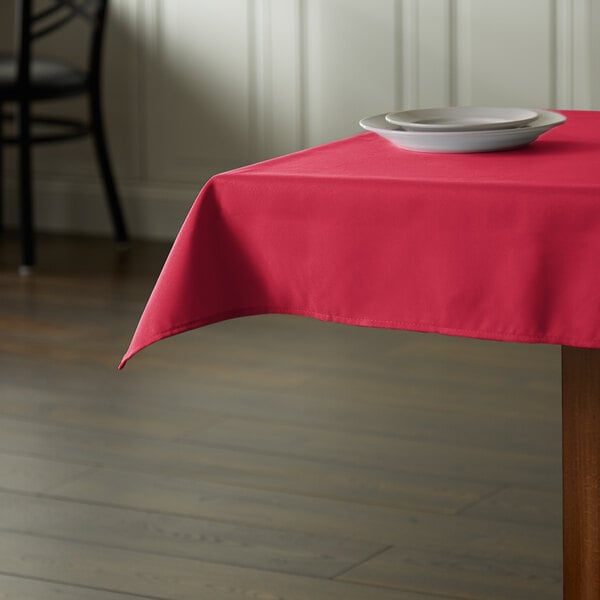 A hot pink Intedge cloth table cover on a restaurant table.