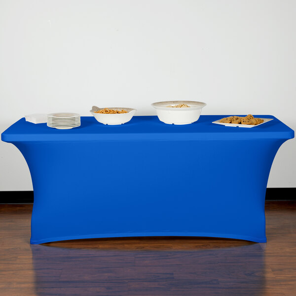 A table with a blue Snap Drape Contour Table Cover and bowls of food on it.