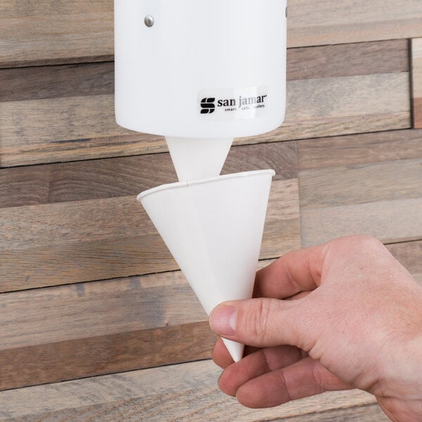 A hand holding a white Bare by Solo paper cone.