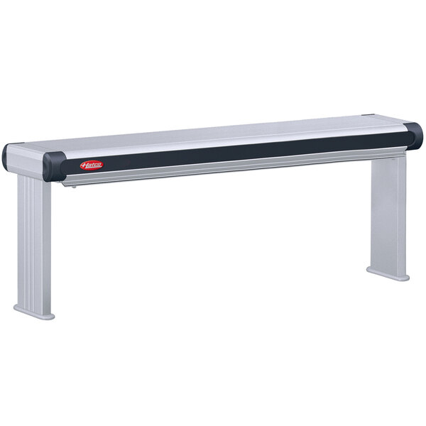 A grey Hatco Glo-Ray infrared strip warmer with red buttons on a metal bench.