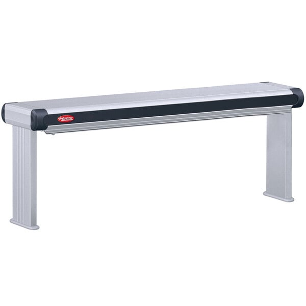 A grey rectangular Hatco infrared strip warmer with red buttons on a long metal bench.