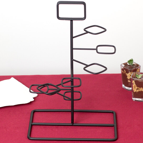 A black metal GET Tower dessert shot display stand with multiple rings on it.