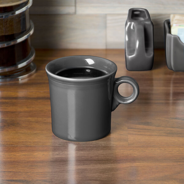 A grey Fiesta china mug filled with a drink on a table.
