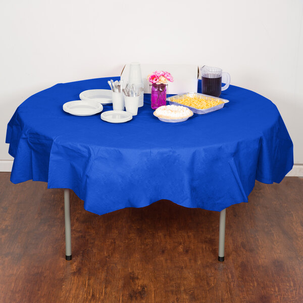 A table with a blue Creative Converting tablecloth, plates, and cups.
