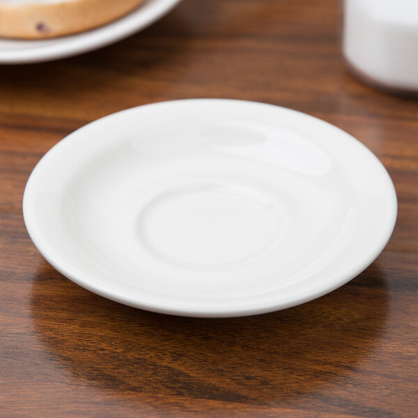 A white Tuxton Nevada saucer on a table.