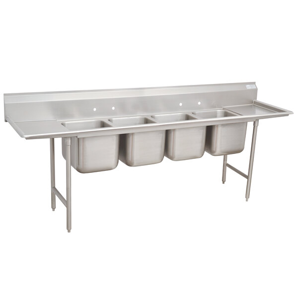 A stainless steel Advance Tabco four compartment pot sink with two drainboards.