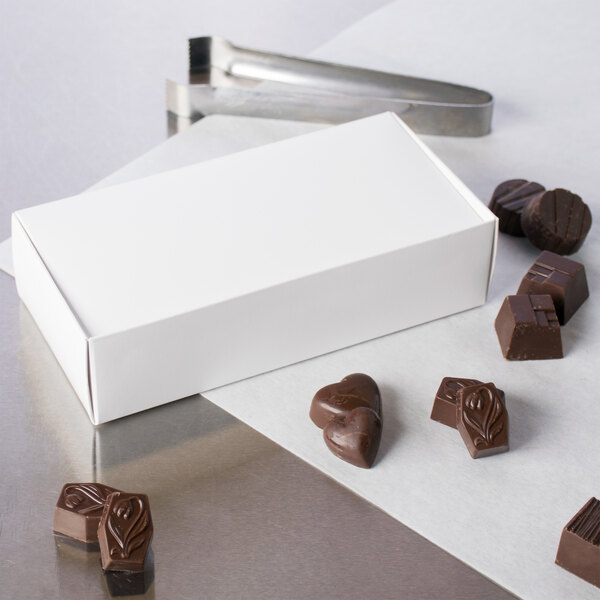 A white 1-piece candy box filled with heart shaped chocolates.