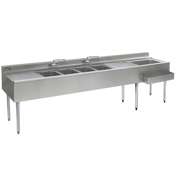 An Eagle Group stainless steel underbar sink with four compartments and a right side ice bin on a counter.