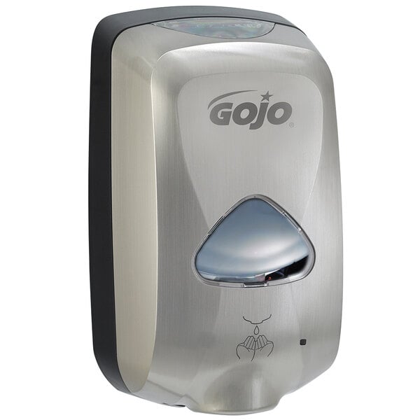 A close-up of a silver and black GOJO® stainless steel soap dispenser.