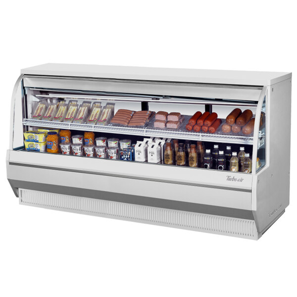 A Turbo Air white refrigerated deli case with food on shelves.