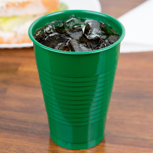 A Creative Converting emerald green plastic cup with ice in it.