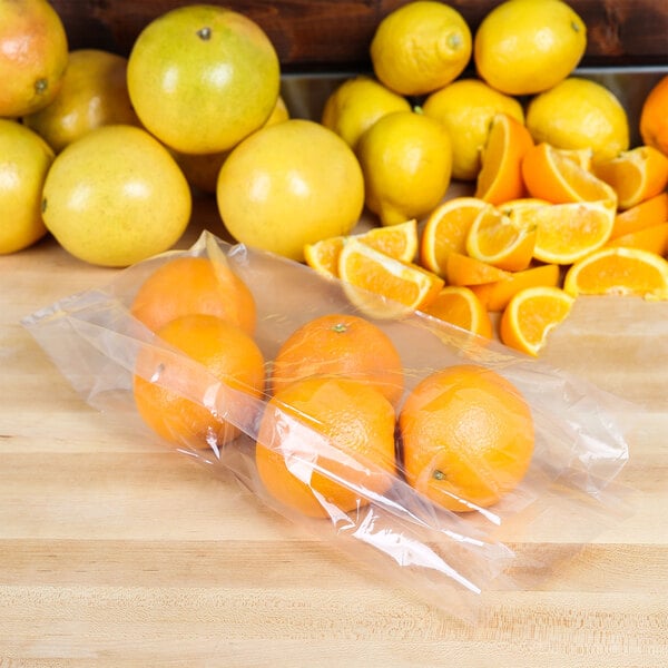 A bunch of oranges in an LK Packaging plastic bag on a table.