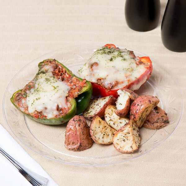 A Choice Crystal clear plastic plate with stuffed peppers, potatoes, cheese, and vegetables.